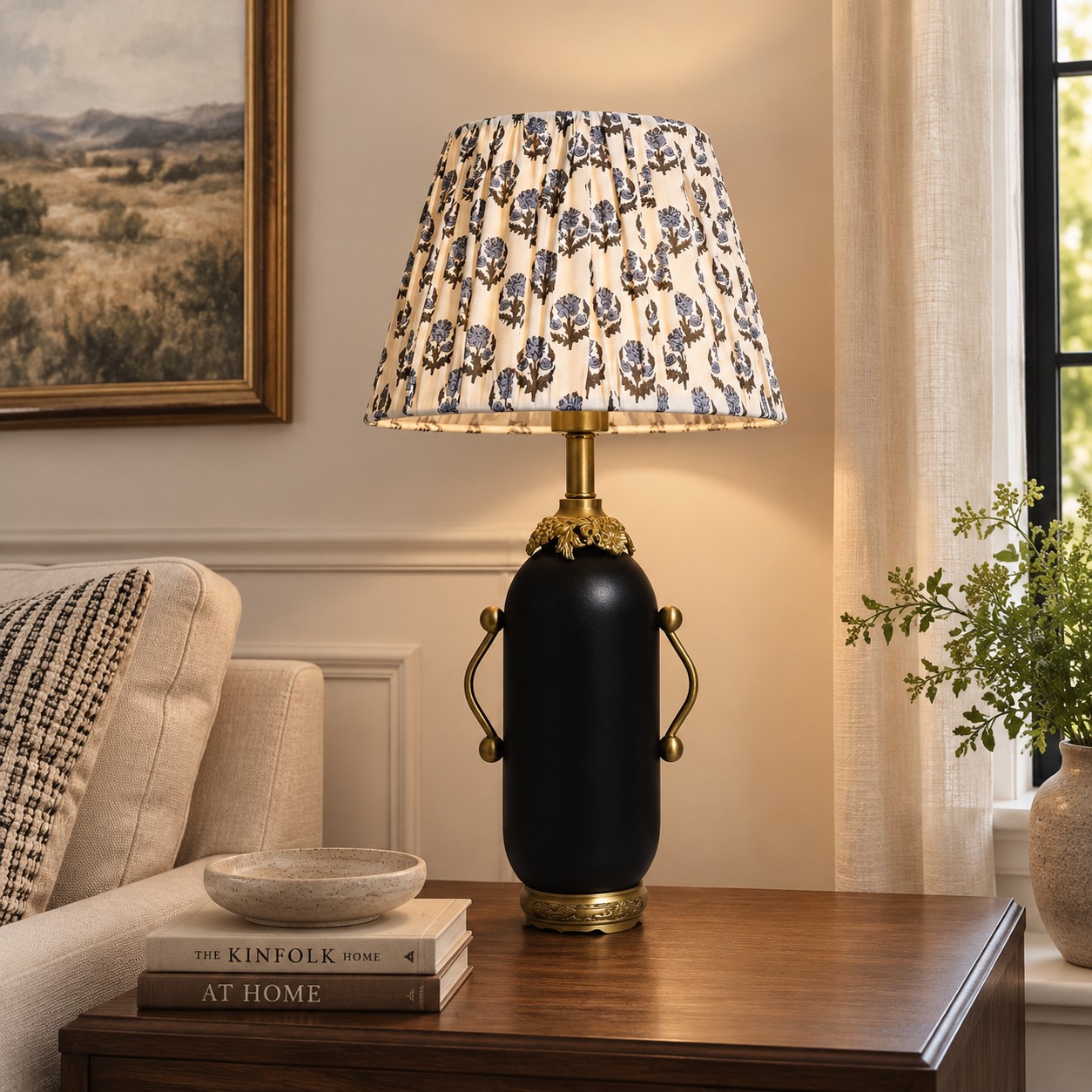 Matte black floral table lamp glowing on a dark side table