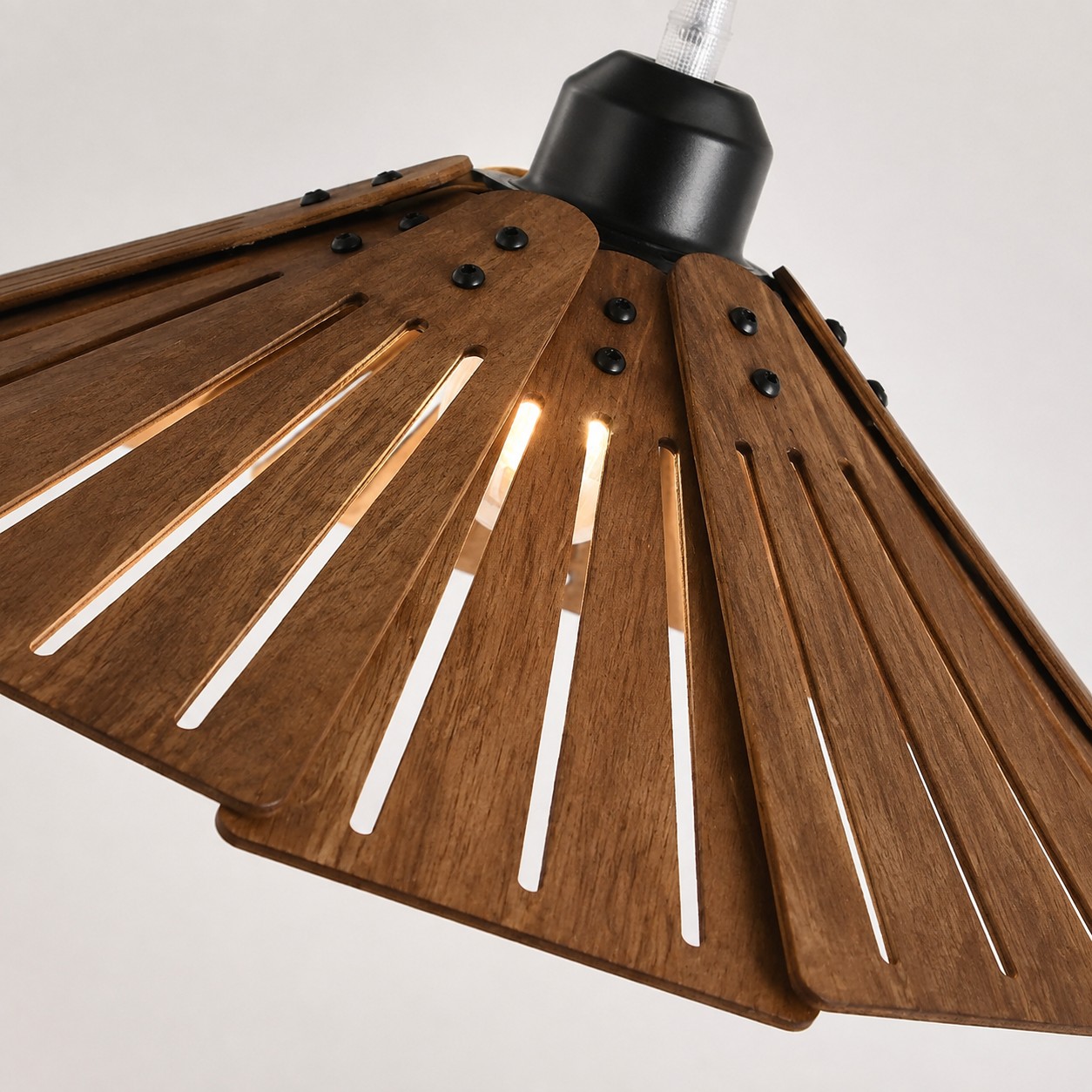 Detailweergave van de gelaagde houten lamellenkap en de zwarte bevestigingsmaterialen.